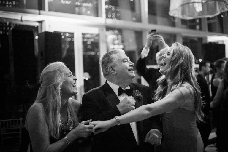 Reception fun as girls dance around grooms father