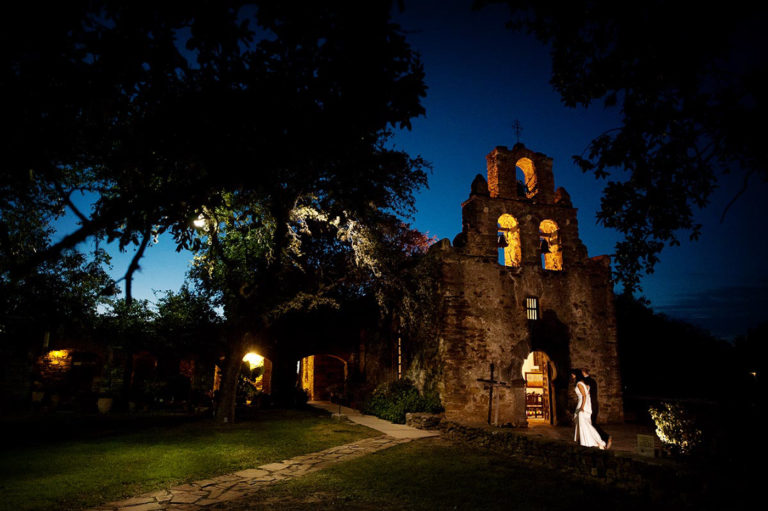 A couple enter their wedding ceremony at one of the historical missions in San Antonio, Texas