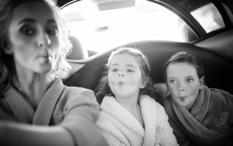 En route to a wedding in San Antonio, Texas, girls take a selfie in limo.