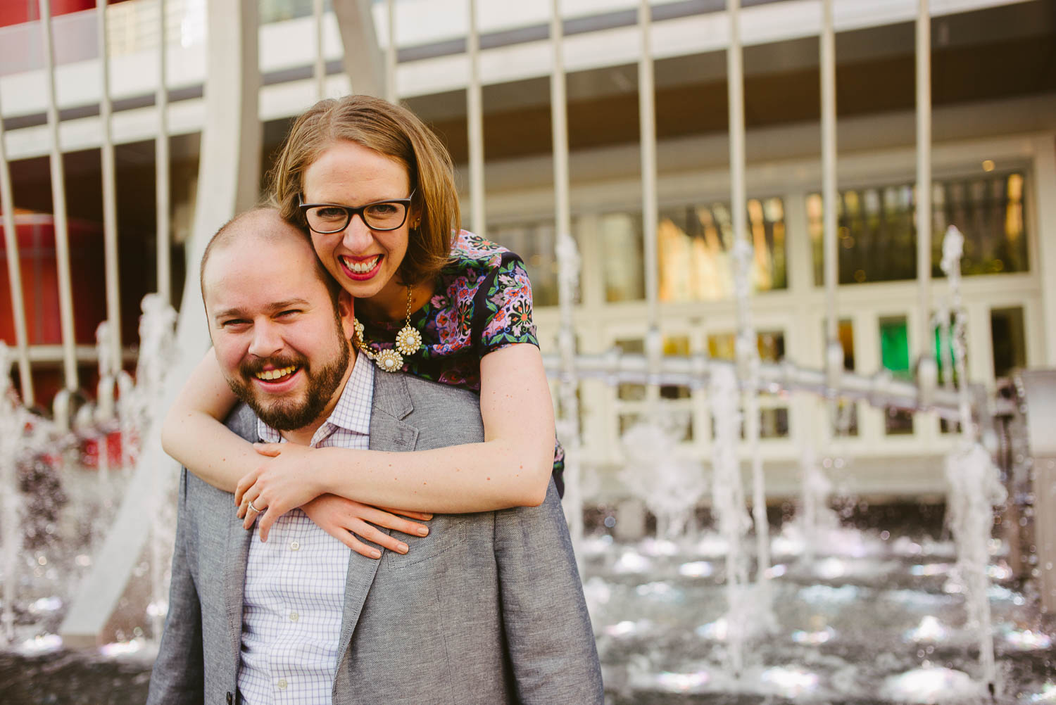 Katie hugs Jimmy from behind at Discovery Green engagement shoot -Philip Thomas Photography