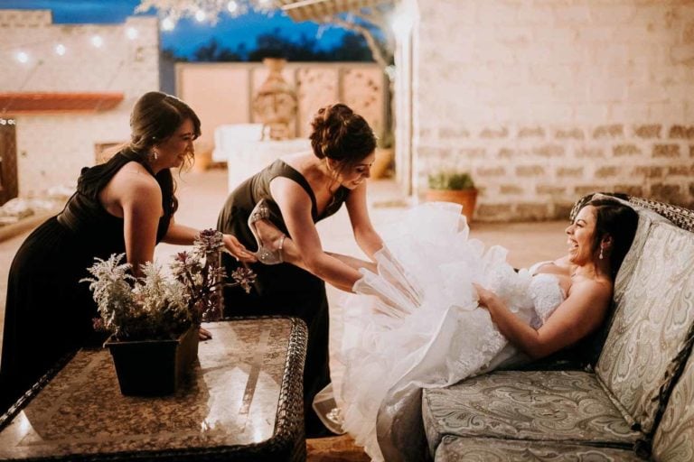 Mother and sister help adjust a brides garter in a humorous moment The Oaks at Heavenly Wedding and reception-Leica photographer-Philip Thomas Photography