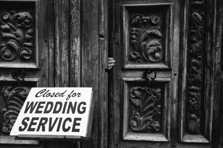 A hand opens the San Jose Missions door San Antonio Wedding Photographer