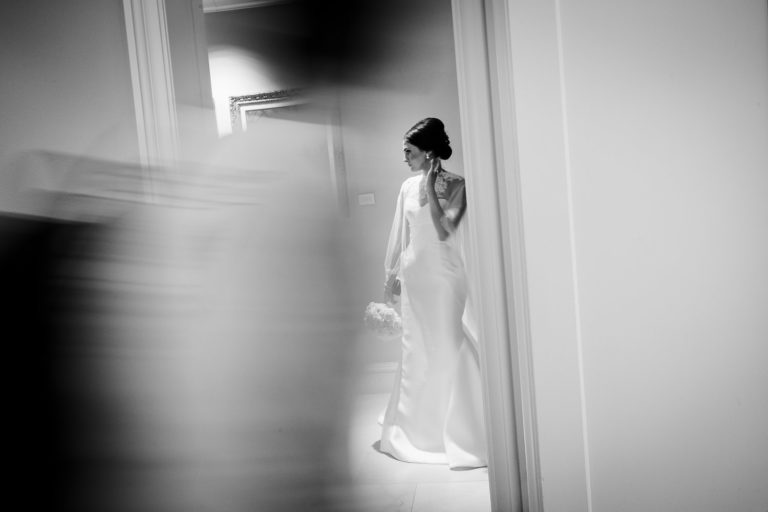 San Antonio Texas. Bride-waits-for-her-ride-to-the-church-at-The-Westin-Riverwalk-has-hotel-guests-walk-past-motion-and-light-Philip-Thomas-Photography