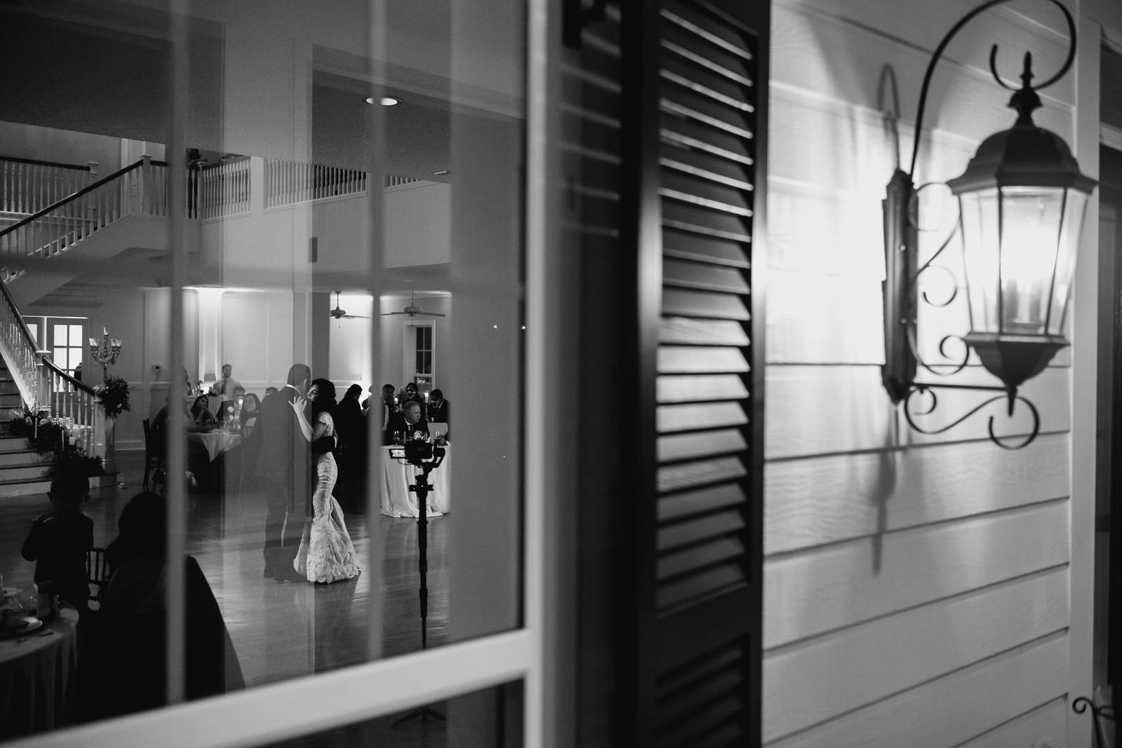 The bride and groom have their first dance with framed in the window 