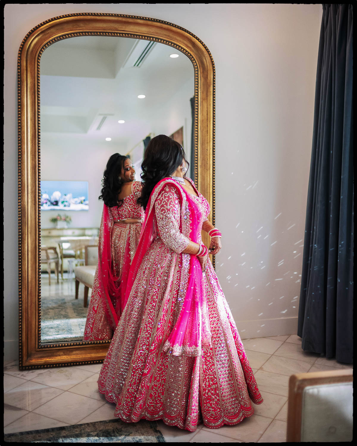 a woman in a pink dress looking in a mirror