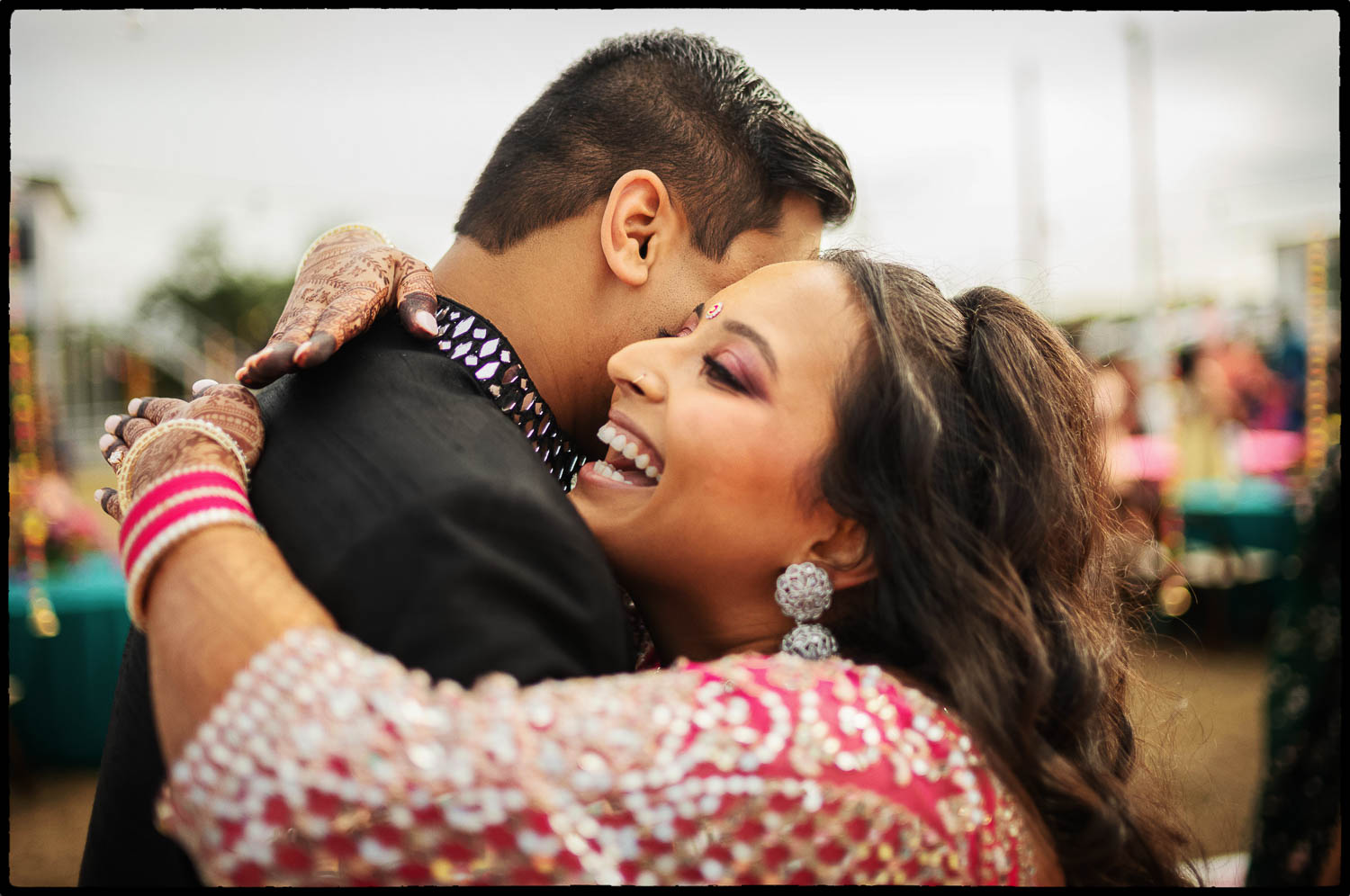 a man and woman hugging during the sangeet