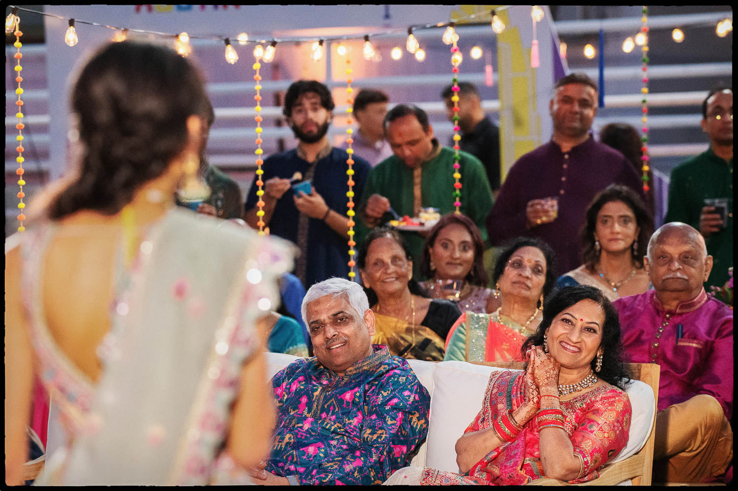 a group of people sitting on a couch during toasts at the Sangeet The Videre Estate