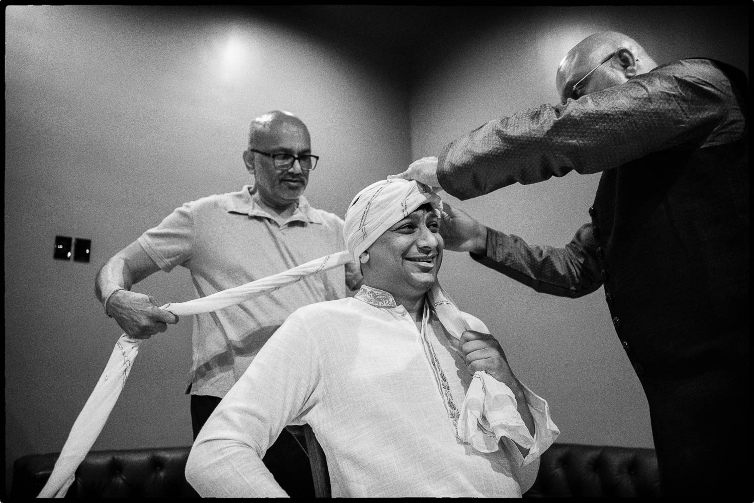 a man tying a man's head with a scarf around his neck