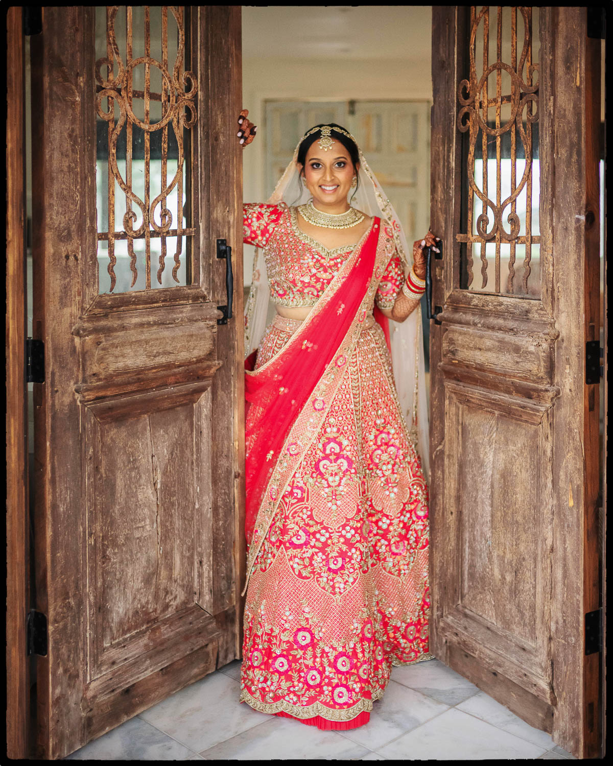 a woman in a red sari posing in doorway at The Videre Estate