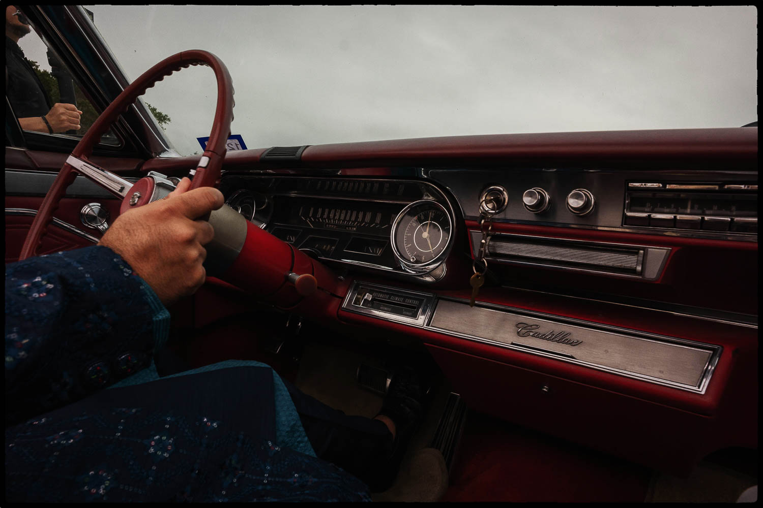 a person holding a steering wheel in a Cadillac
