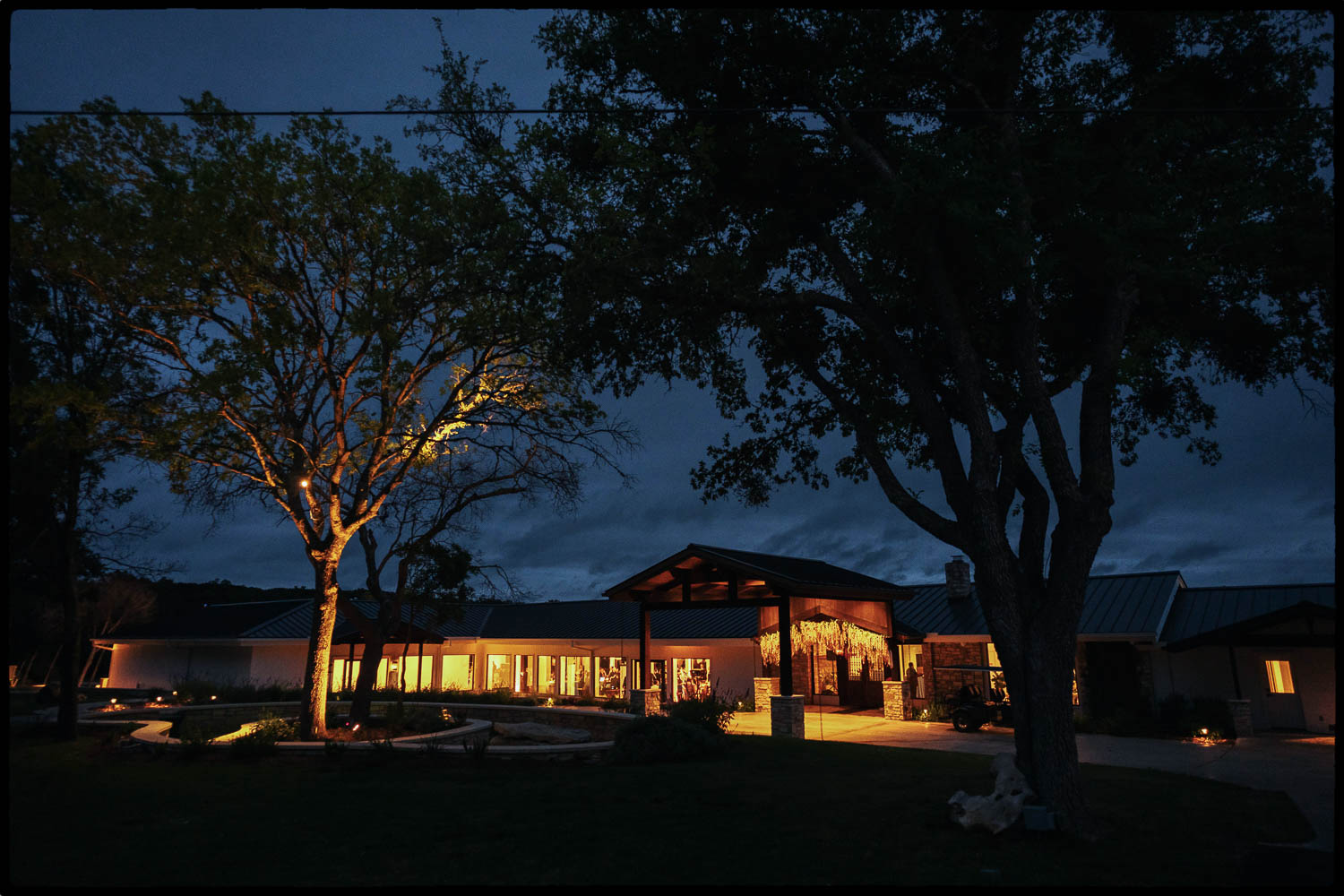 a building with lights on the outside The Videre Estate South Asian Wedding in Wimberley Texas