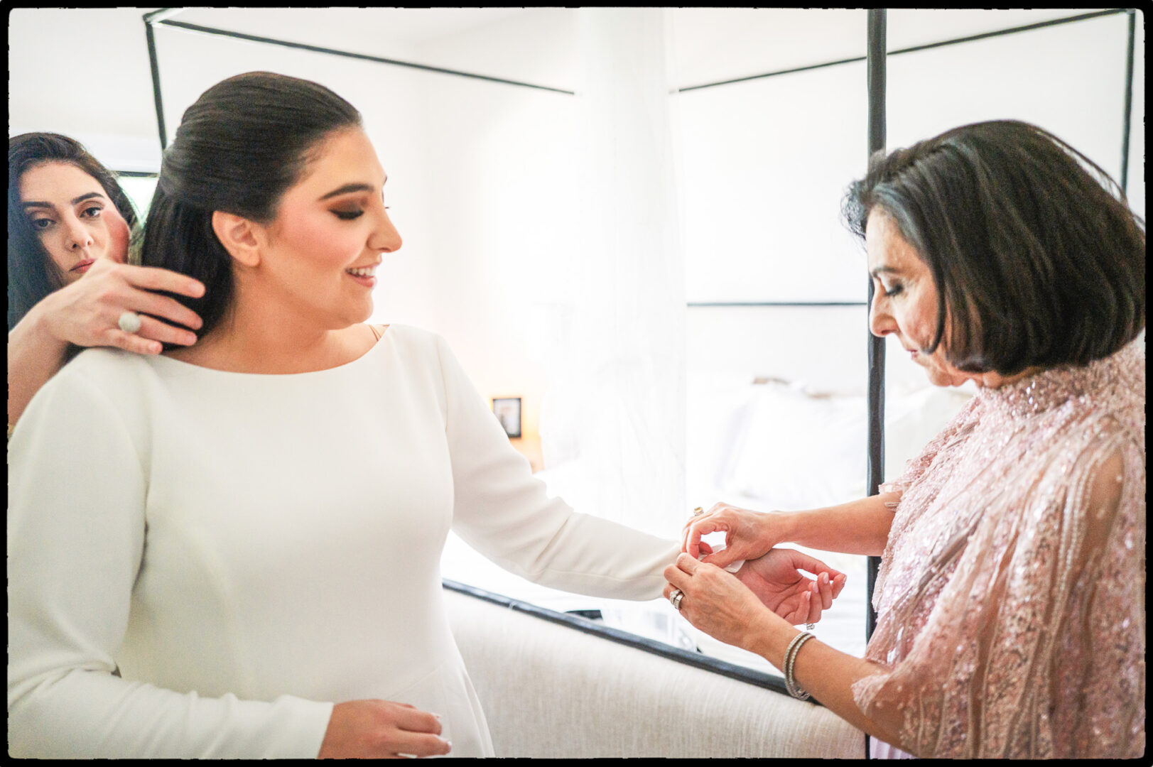 mother of the bride helping the bride dress