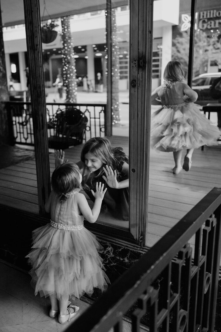 Flower girls in shop window at San Antonio's Devils Distillery Flower girls from a window play in shop window L1003477